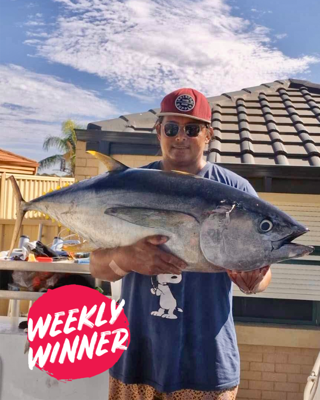 Angler holding large bluefin tuna caught offshore from Mandurah waters