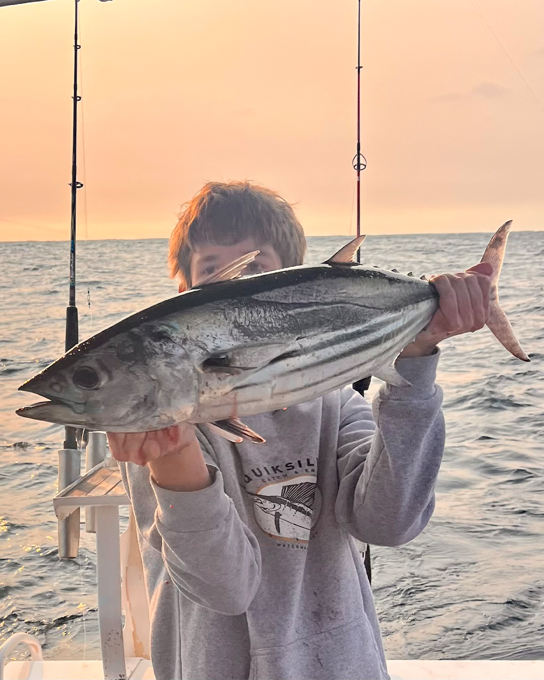 Angler displaying striped fish caught in Mandurah estuary waters