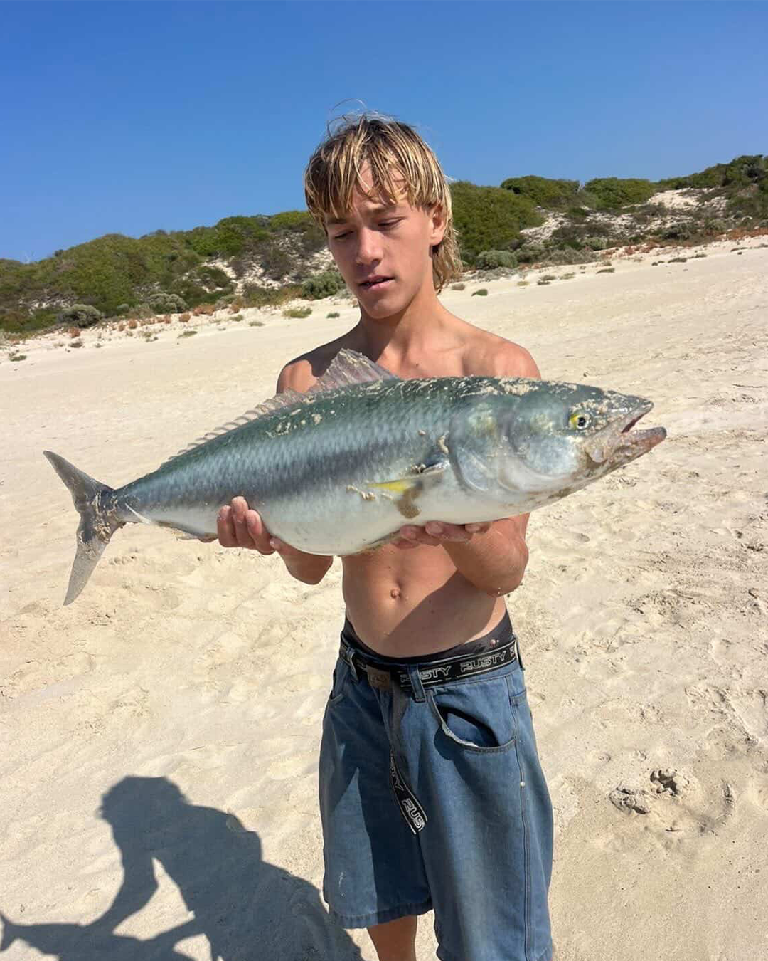 Angler holding salmon caught during beach fishing session