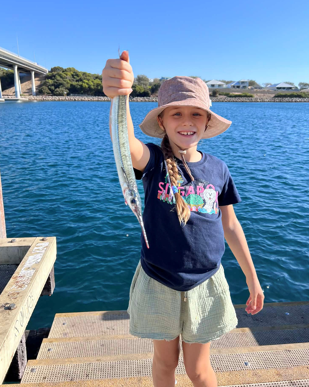 Young angler Liesel proudly showing her first fishing catch