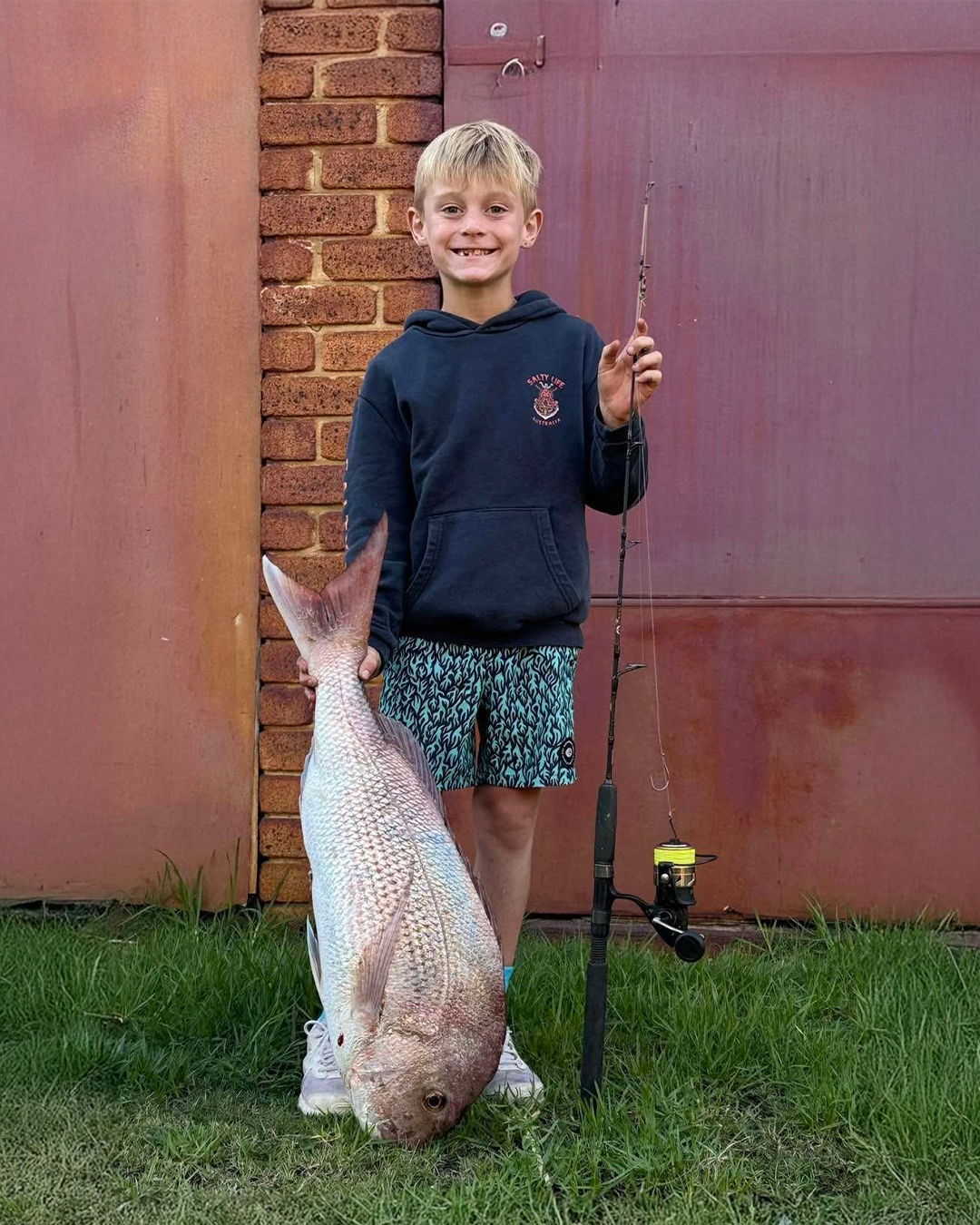 Shore angler holding pink snapper caught from Mandurah boat ramp