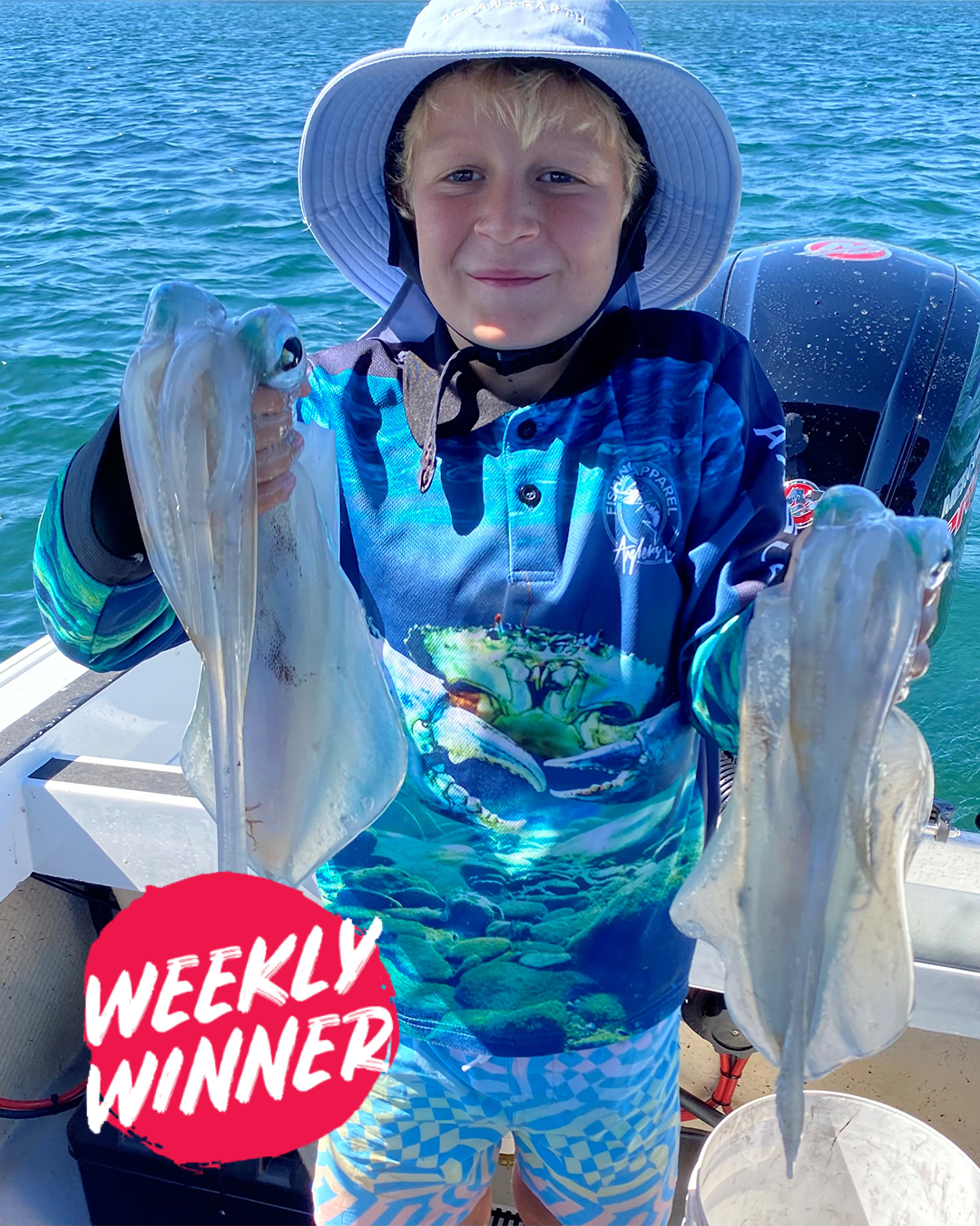 Angler Ryan displaying two large squid caught in Mandurah waters