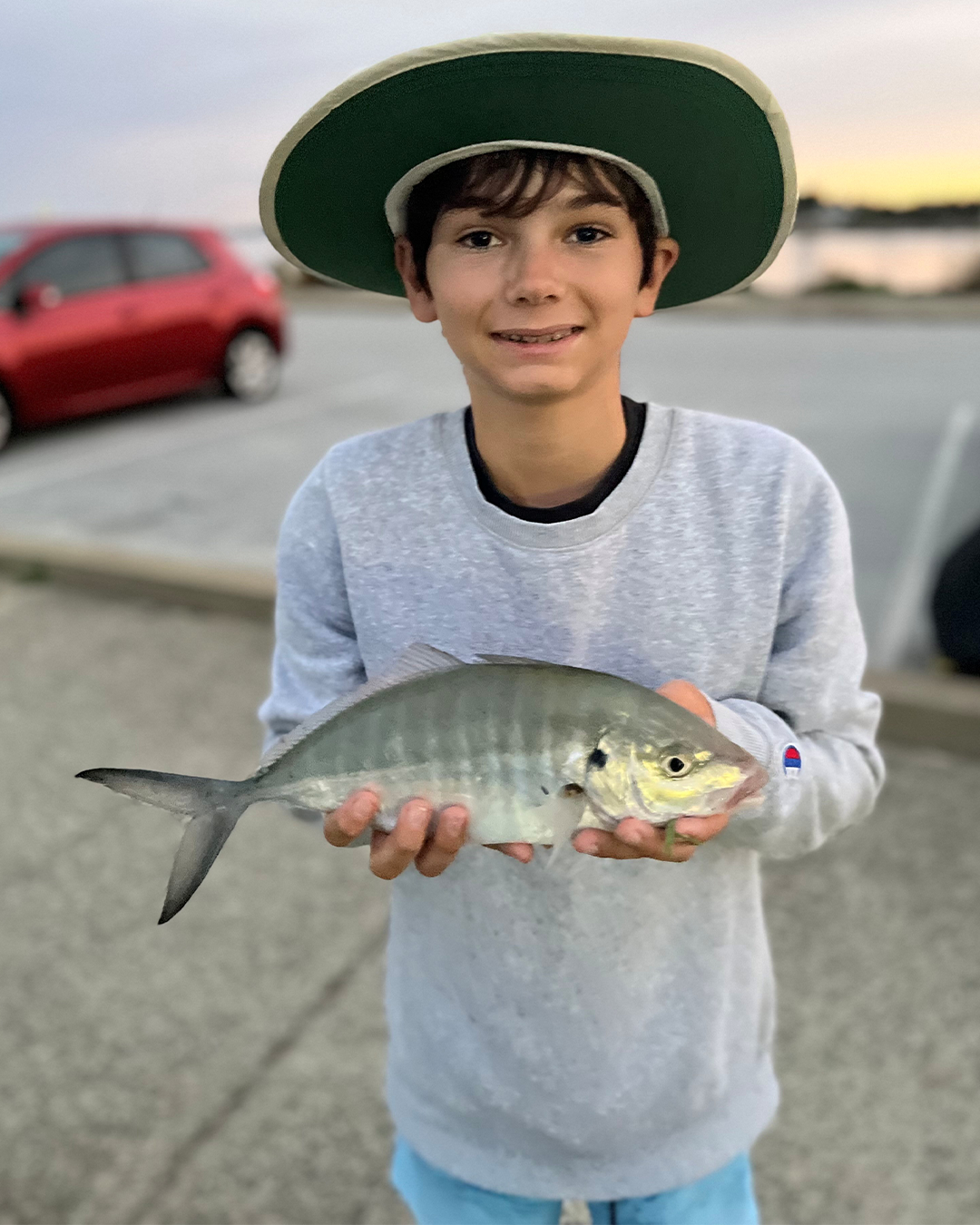 Angler Cohan holding skipjack tuna caught in winter conditions near Mandurah