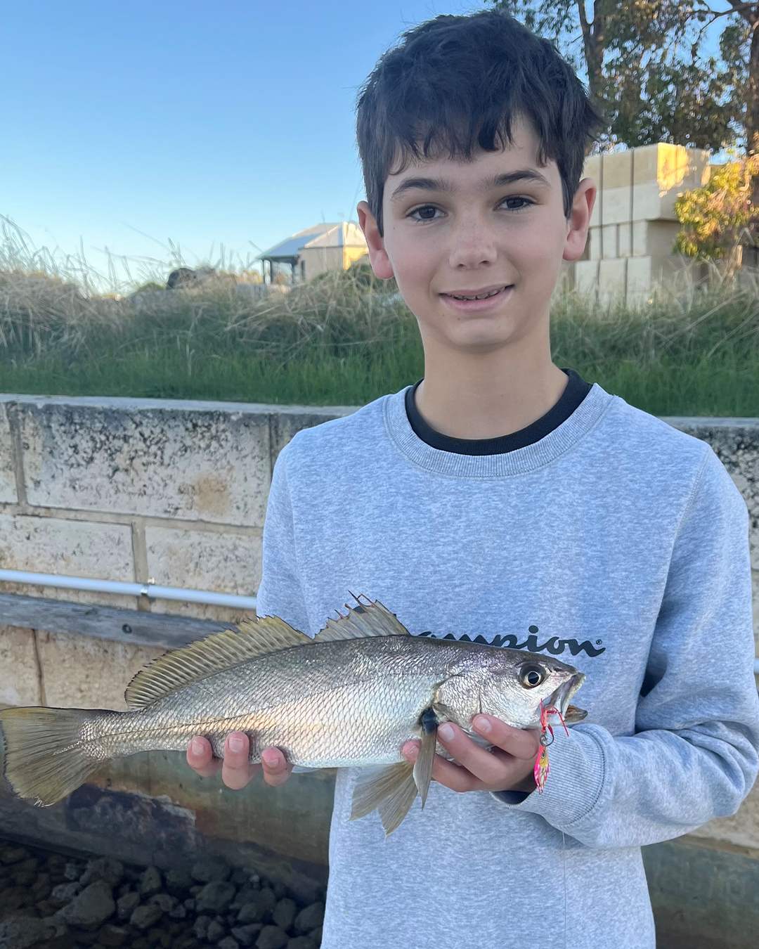 Angler Cohen holding a soapy snapper caught on a Roven micro lure in Mandurah