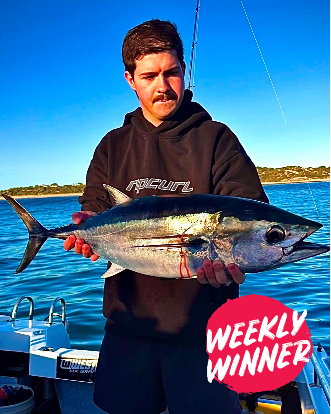 Angler Louie holding a Bluefin Tuna caught in shallow water during winter off Mandurah