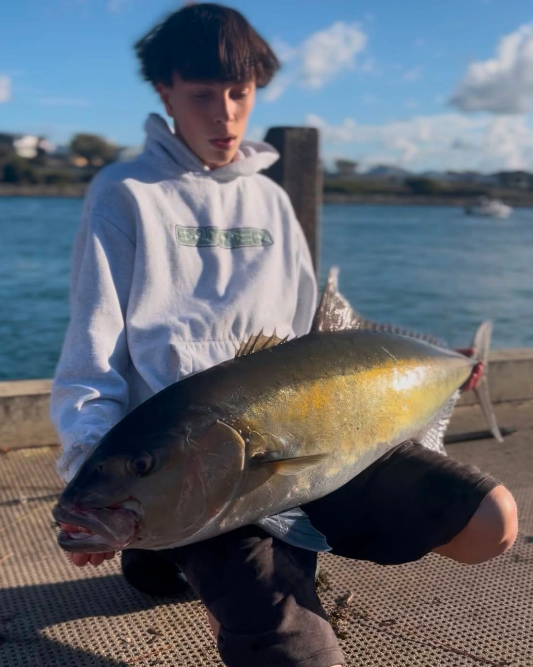 Angler Luke fighting a large Samsonfish from the shore along a Mandurah beach
