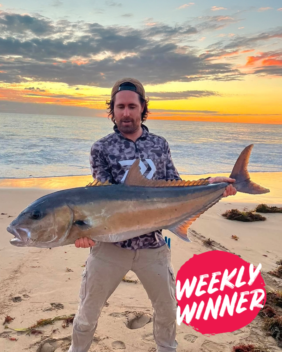 Angler Aaron holding a Sambo caught land-based at sunset on a Mandurah beach