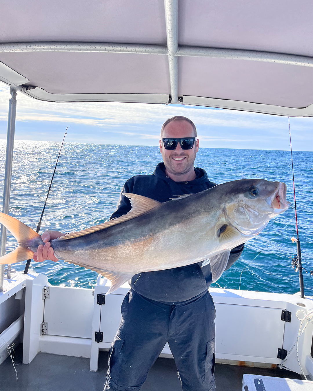 Angler holding a large Samson fish caught on a sunny winter day off Mandurah