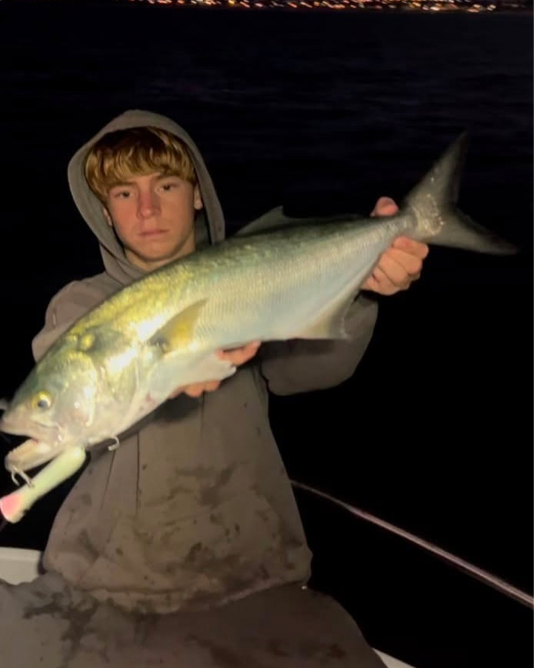 Angler Riley holding a solid Tailor caught after dark fishing the Mandurah coast