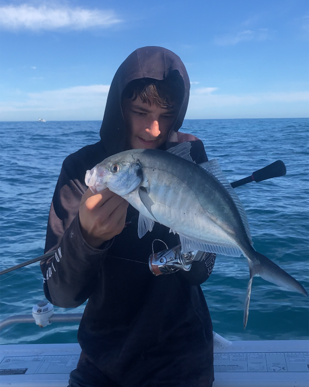 Angler holding a skippy caught on light gear along Mandurah inshore structure in winter