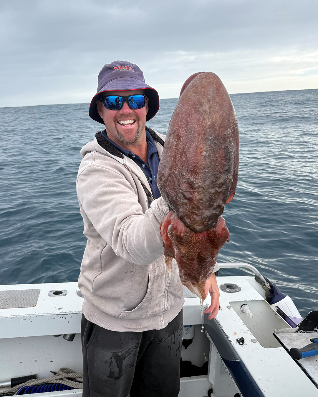 Angler Chris holding a freshly caught cuttlefish, known to taste sweeter than squid