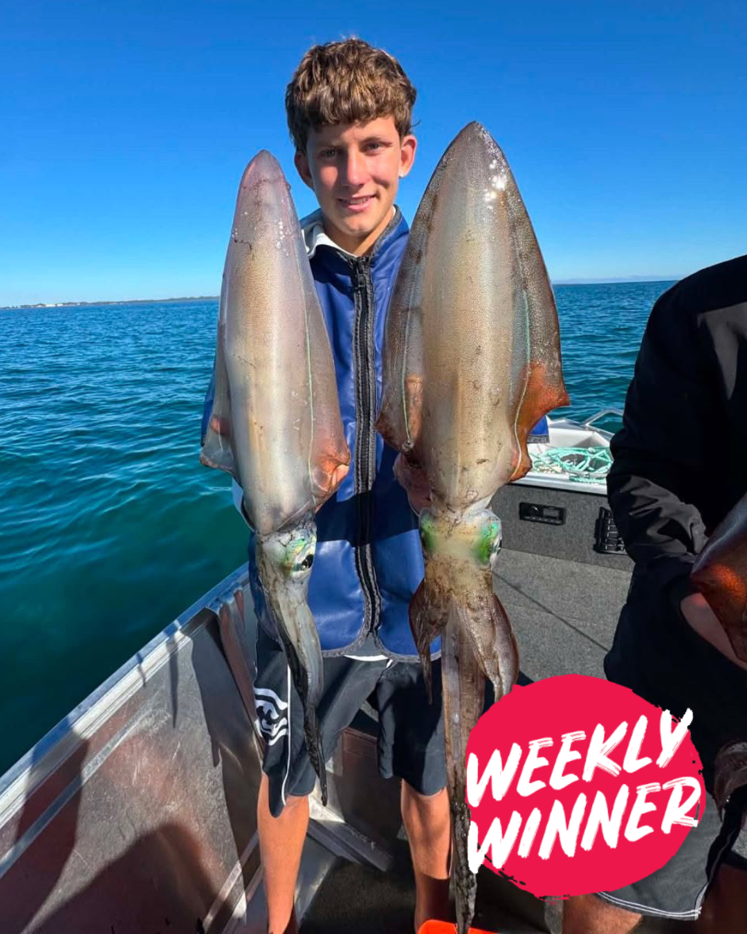 Logan holding a haul of large squid caught in Mandurah inshore waters