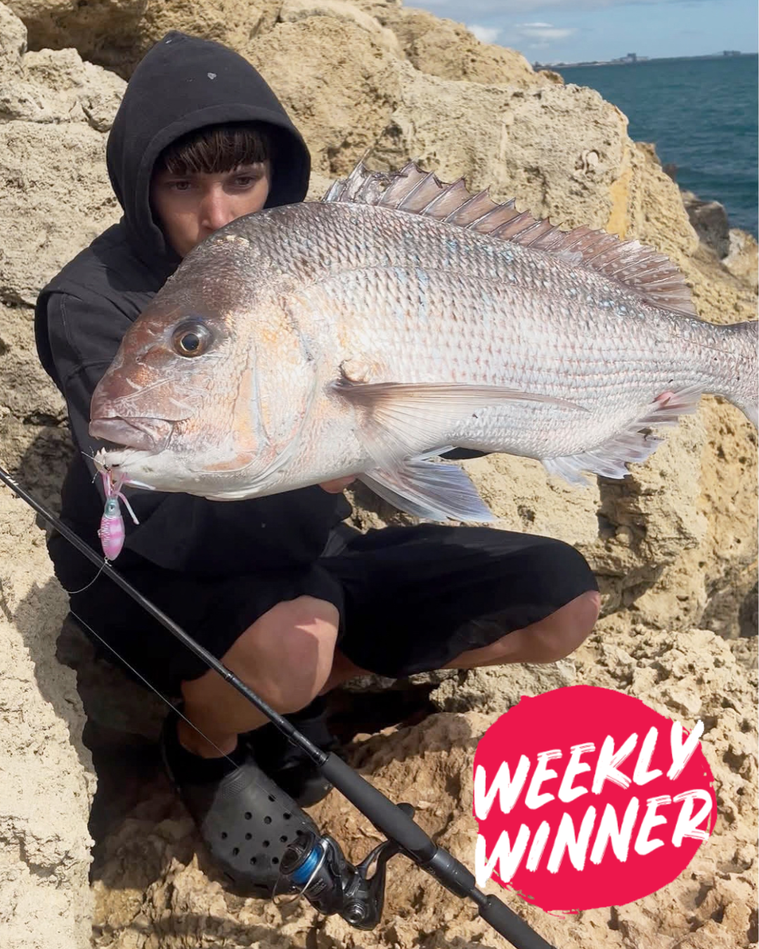 Angler Luke holding a pink snapper caught land-based on a lure near Mandurah