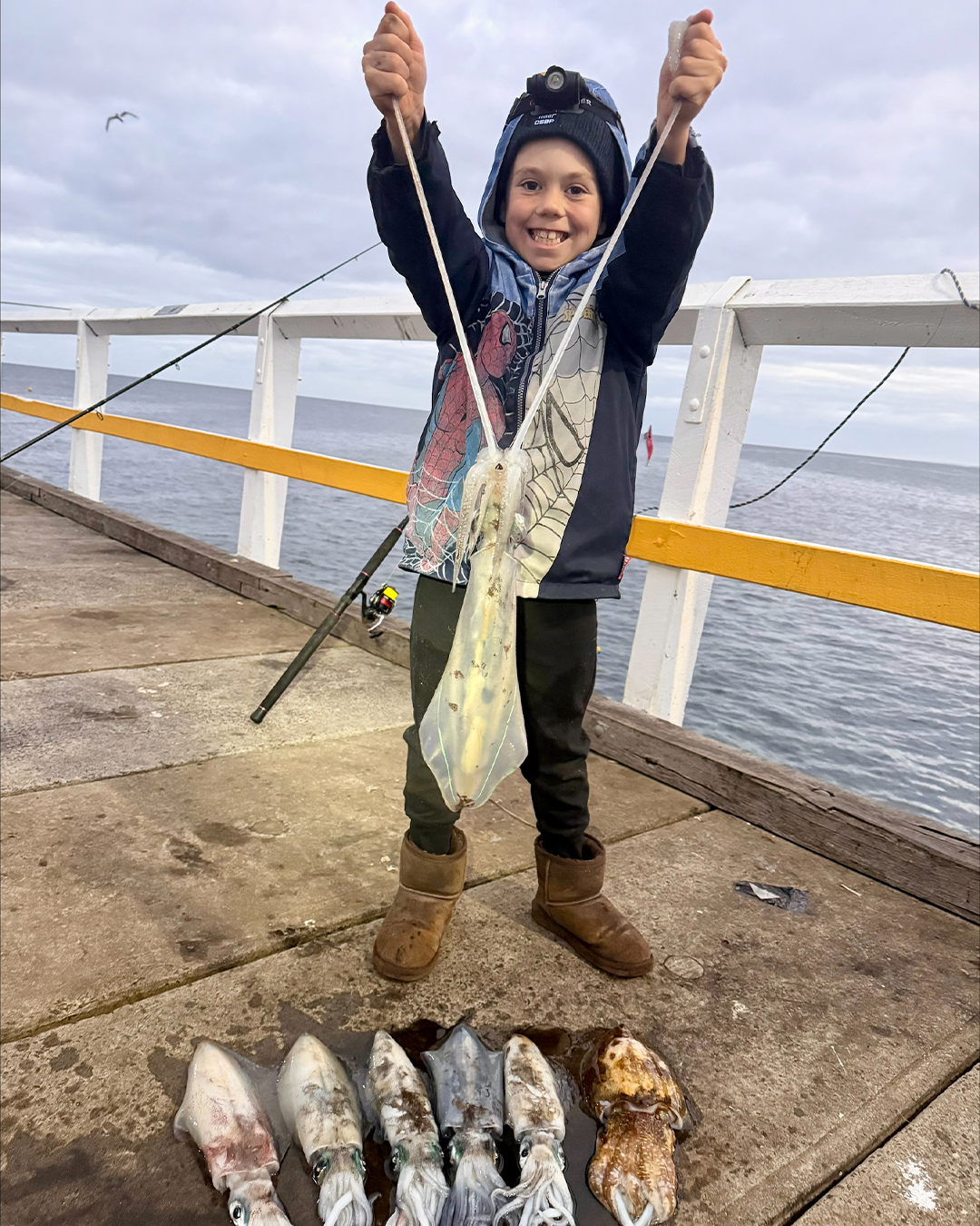 Young angler Theo holding a haul of squid he caught by himself near Mandurah