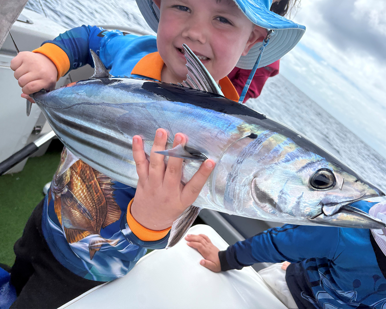 Angler Tristan and family with a locally caught tuna during spring fishing action near Mandurah