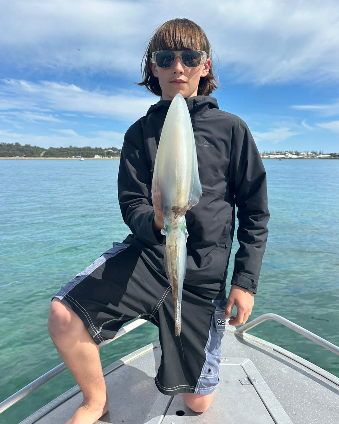 Young angler Zeathan holding an early season squid caught in Mandurah's sheltered waterways