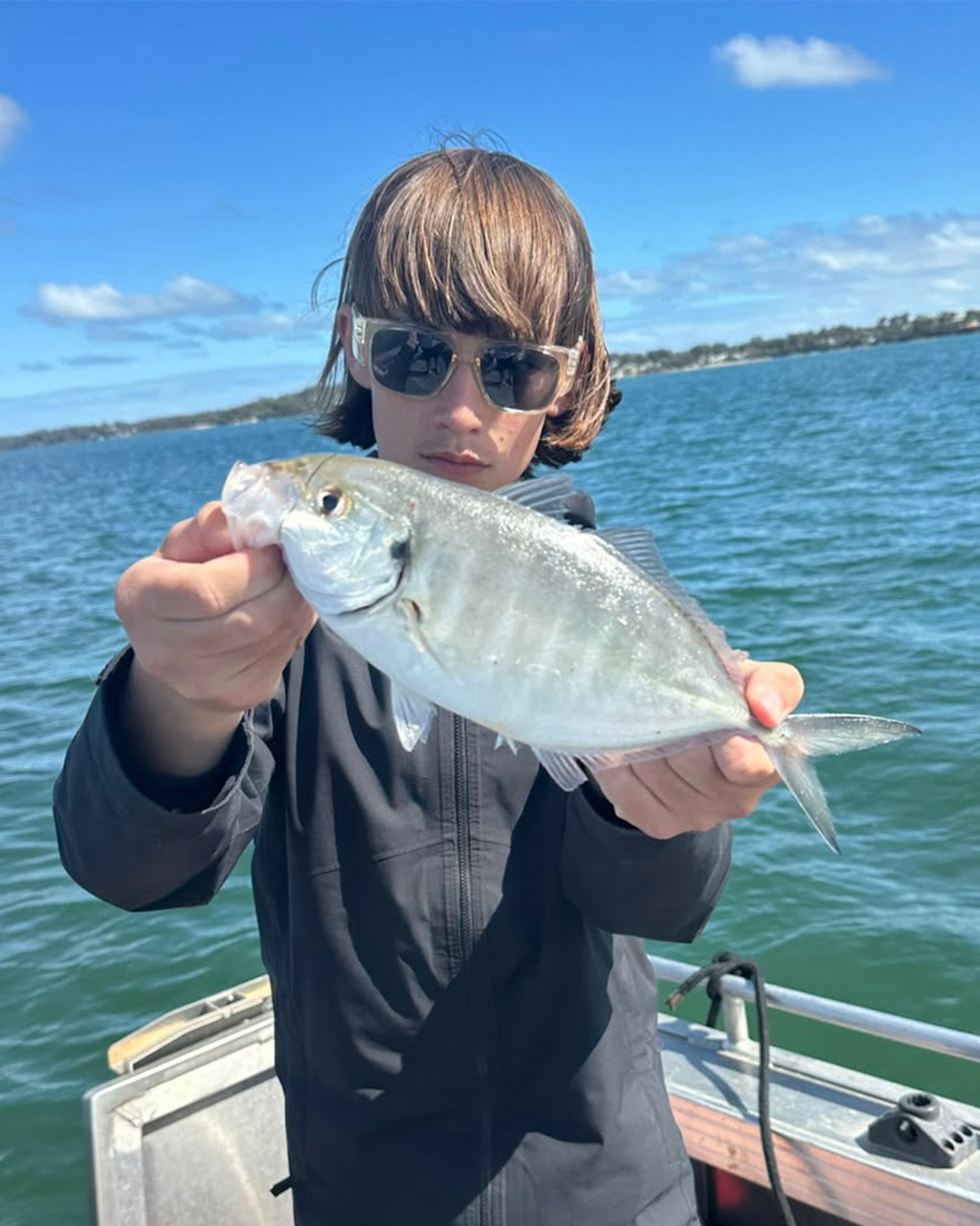 Angler Zeathan holding a collection of skipjack tuna caught inshore near Mandurah